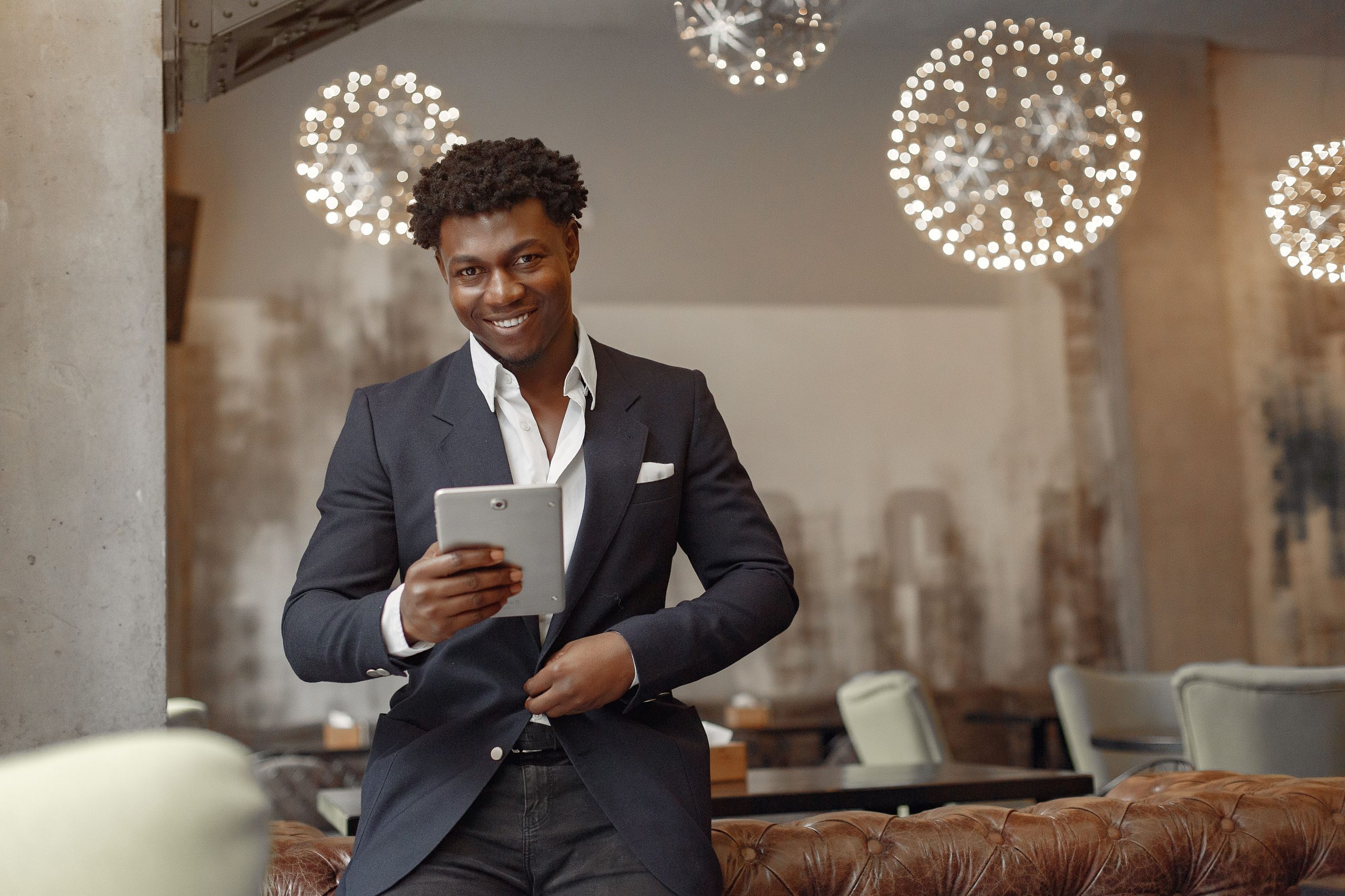 Empresário do setor da restauração a consultar o tablet no seu estabelecimento, setor elegível ao Voucher Digital (CAE 56)